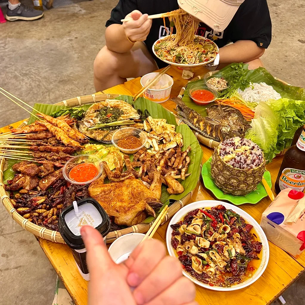 Dai style barbecue 地道西雙版納傣味燒烤盛宴。烤魚、串燒、烤雞、菠蘿飯與香辣蘸料鋪在芭蕉葉上,是繽紛的雲南街頭美食。