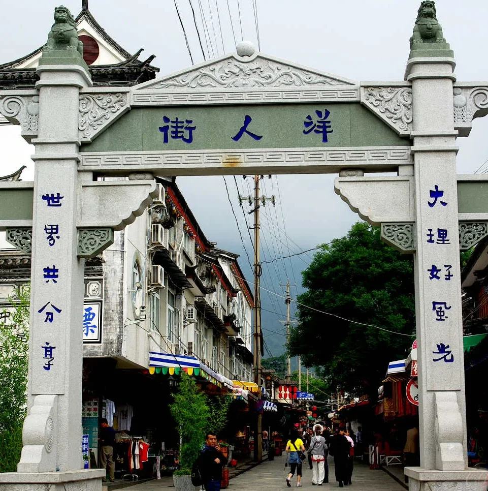 Dali Foreigners Street 1 e1774959761821 大理洋人街牌坊,傳統石雕門樓與街道景象,展現古城熱鬧氛圍。