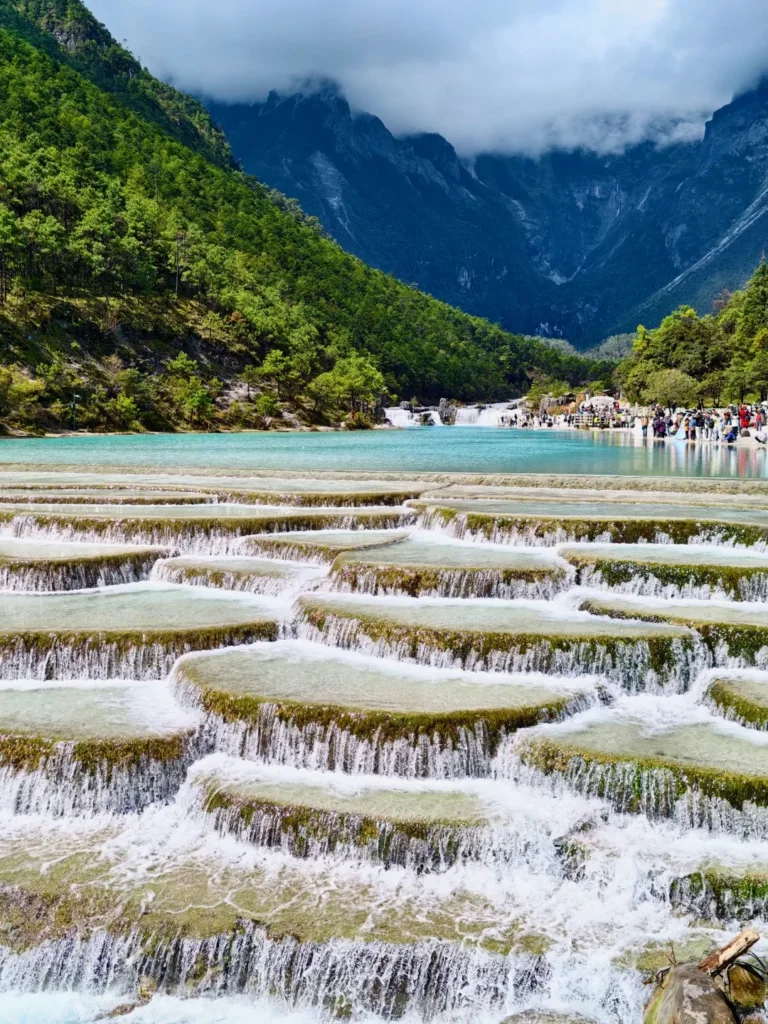 Blue Moon Valley 3 麗江藍月谷層層瀑布與藍色湖水,周圍環繞綠色山林。