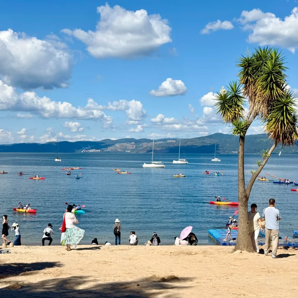 Fuxian Lake4 玉溪撫仙湖的沙灘度假風景,藍天白雲下的澄澈湖水、彩色小船與熱帶樹木,是雲南版的海邊度假勝地。